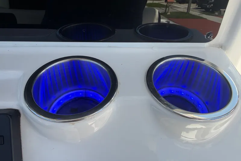 Slide: The Image of Close-up of illuminated blue cup holders on a 2022 Tidewater 2410 Bay Max boat. - 28