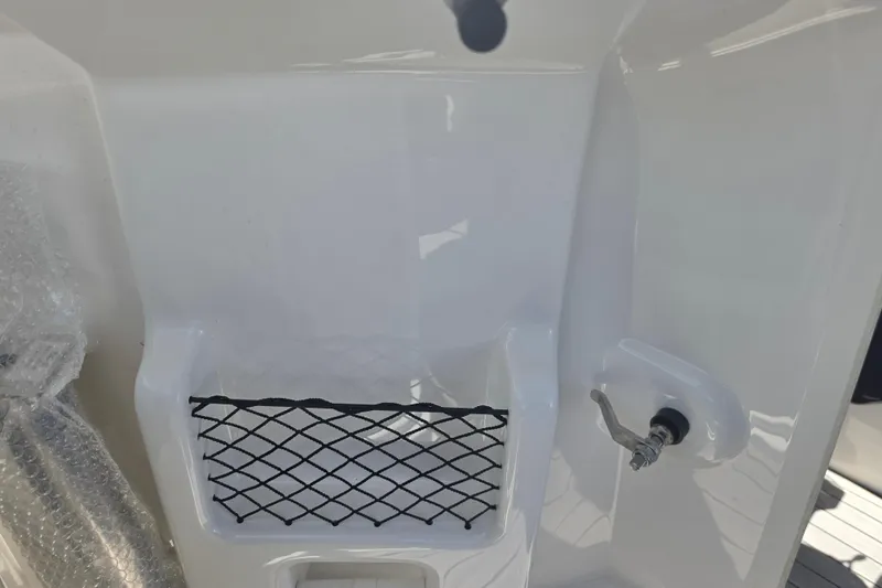 Slide: The Image of 2022 Yamaha Boats 252SD interior detail with storage net and valve handle. - 48