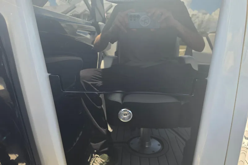 Slide: The Image of Reflection on Yamaha Boats 252SD 2022 cabin door with visible seating. - 36