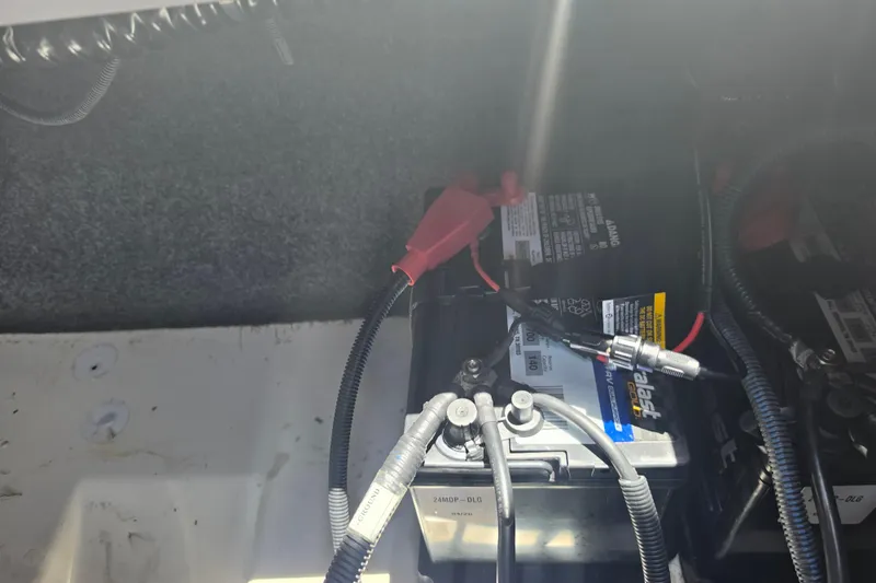 Slide: The Image of Battery compartment of a 2022 Yamaha Boats 252SD, featuring connected cables and wiring. - 94