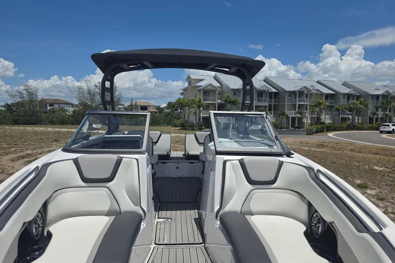 Slide: The Image of 2022 Yamaha Boats 252SD interior with sleek seating and modern design under a clear blue sky. - 83