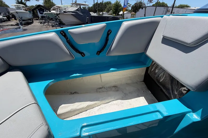 Slide: The Image of 2023 Heyday WTSurf boat interior with open storage compartment, blue and gray seating. - 91
