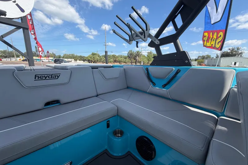 Slide: The Image of 2023 Heyday WTSurf boat interior with gray seating and blue accents under a clear sky. - 39