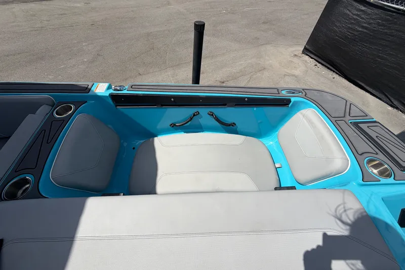 Slide: The Image of 2023 Heyday WTSurf boat interior with blue and gray seating, cup holders, and handle. - 46