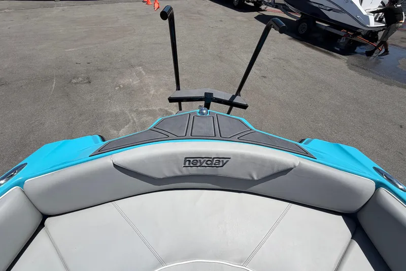 Slide: The Image of 2023 Heyday WTSurf boat interior with blue and gray seating, docked on pavement. - 92