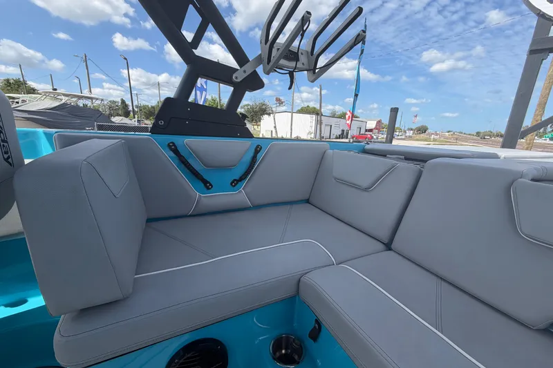 Slide: The Image of 2023 Heyday WTSurf boat interior with gray seating and blue accents under a clear sky. - 27