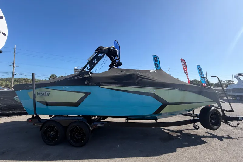 Slide: The Image of 2023 Heyday WTSurf boat with cover on trailer, displayed outdoors. - 93