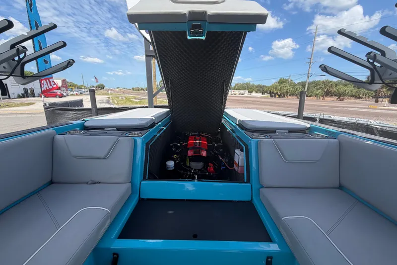 Slide: The Image of 2023 Heyday WTSurf boat interior with open engine compartment, blue and gray seating. - 32
