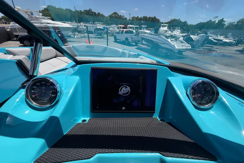 Slide: The Image of 2023 Heyday WTSurf boat dashboard with speedometer and tachometer in a marina setting. - 67