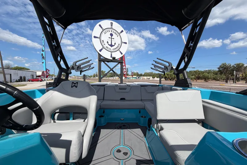 Slide: The Image of 2023 Heyday WTSurf boat interior with gray seats and blue accents under a sunny sky. - 23