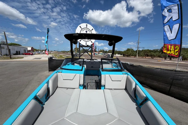 Slide: The Image of 2023 Heyday WTSurf boat with blue and gray interior, displayed outdoors under a sunny sky. - 17