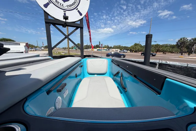 Slide: The Image of 2023 Heyday WTSurf boat interior with blue and white seating, parked outdoors. - 53