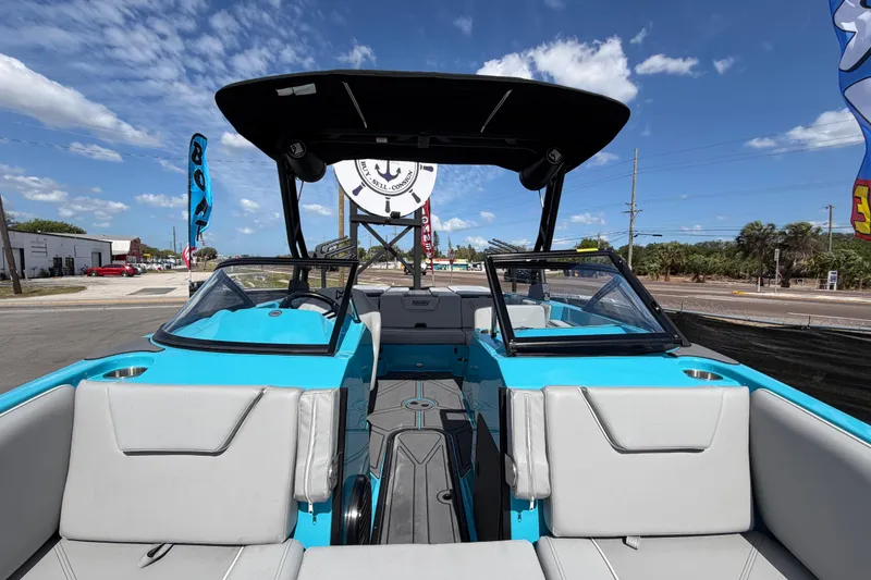Slide: The Image of 2023 Heyday WTSurf boat with blue and white interior, parked outdoors under a clear sky. - 20