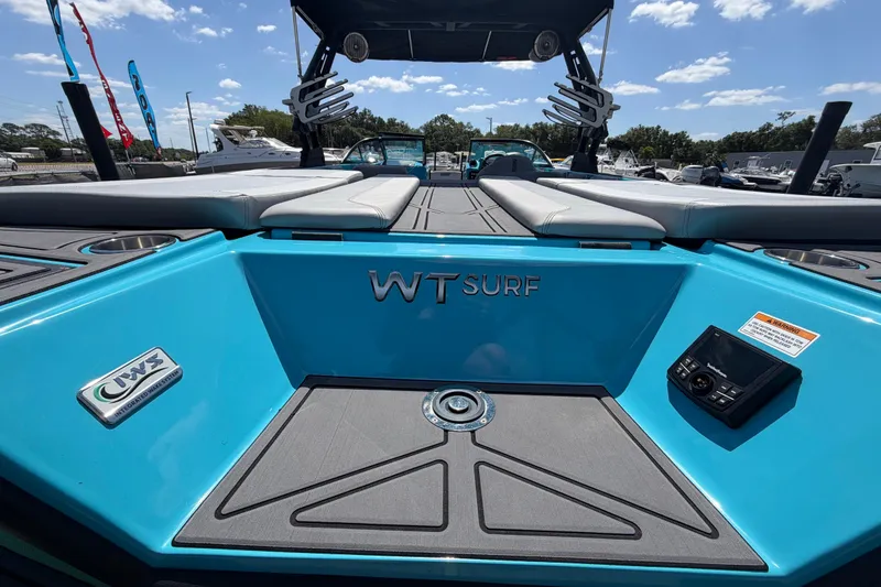 Slide: The Image of 2023 Heyday WTSurf boat interior with blue accents and seating under a sunny sky. - 56