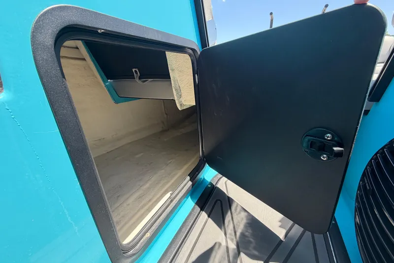 Slide: The Image of Open storage compartment on 2023 Heyday WTSurf boat, featuring a sleek blue exterior. - 80