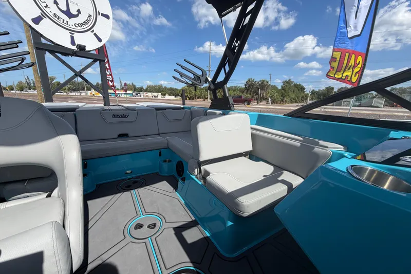 Slide: The Image of 2023 Heyday WTSurf boat interior with gray seating and blue accents under a sunny sky. - 25