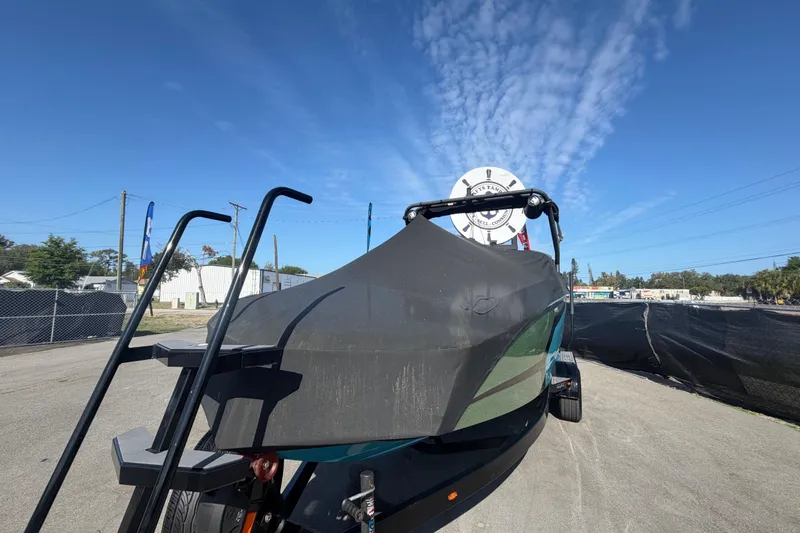 Slide: The Image of 2023 Heyday WTSurf boat covered, parked outdoors under a clear blue sky. - 94