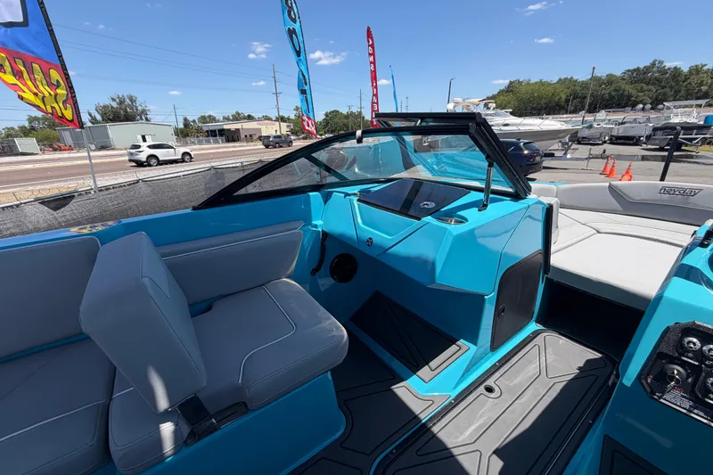 Slide: The Image of 2023 Heyday WTSurf boat interior with blue and gray seating, displayed outdoors. - 70