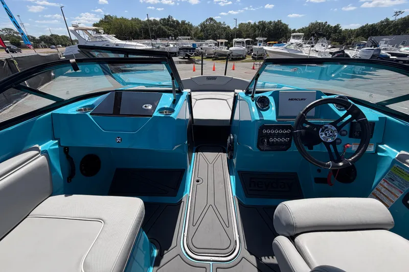 Slide: The Image of 2023 Heyday WTSurf boat interior with steering wheel and seating, docked at marina. - 61