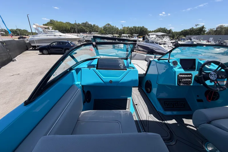 Slide: The Image of 2023 Heyday WTSurf boat interior with blue dashboard and seating at a marina. - 71