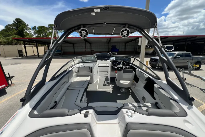 Slide: The Image of 2022 Yamaha Boats AR190 interior with seating and steering wheel, parked outdoors. - 16
