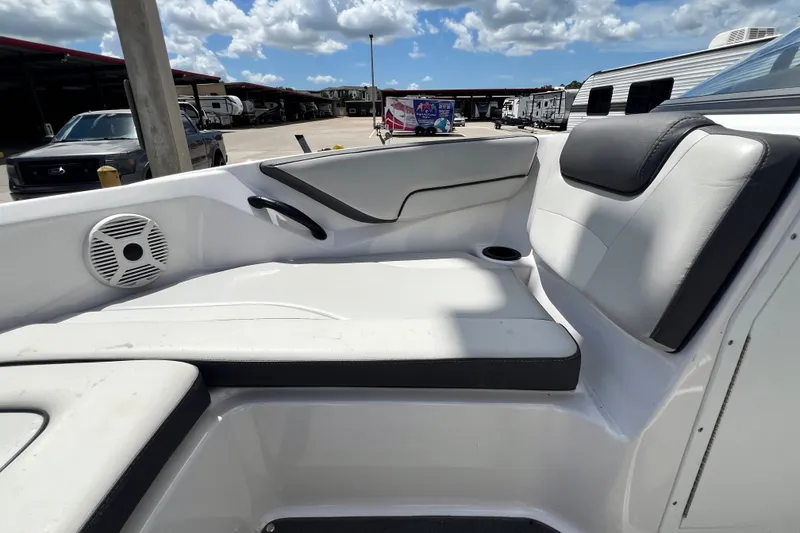 Slide: The Image of 2022 Yamaha AR190 boat interior with white seating and speaker, under a cloudy sky. - 41