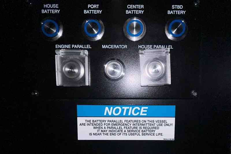 Slide: The Image of Control panel of a 2023 Regal 38 FXO boat with battery switches and notice. - 74