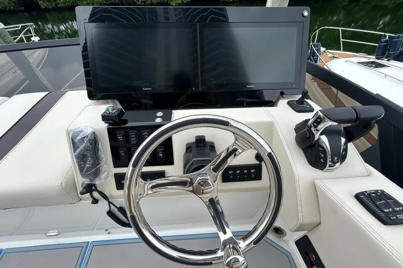 Slide: The Image of Helm of 2023 Regal 38 FXO boat with steering wheel and navigation controls. - 24