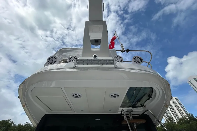 Slide: The Image of 2023 Regal 38 FXO yacht viewed from below against a cloudy sky backdrop. - 18
