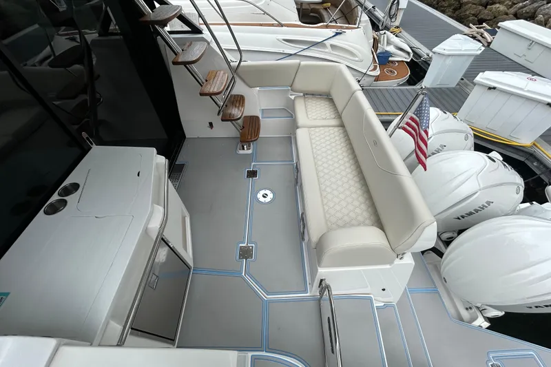 Slide: The Image of 2023 Regal 38 FXO yacht deck with seating, Yamaha engines, and American flag. - 17
