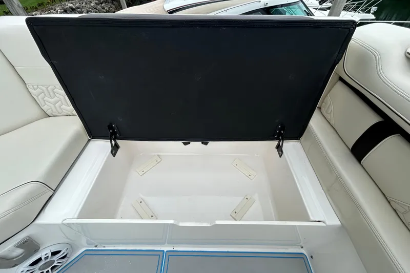 Slide: The Image of Open storage compartment on 2023 Regal 38 FXO boat with cushioned seating. - 30