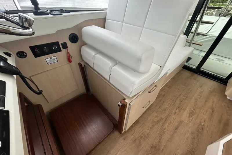 Slide: The Image of 2023 Regal 38 FXO boat interior with white seating and wooden flooring. - 63