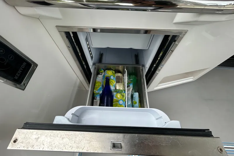 Slide: The Image of Open drawer refrigerator on 2023 Regal 38 FXO yacht, stocked with beverages and snacks. - 47