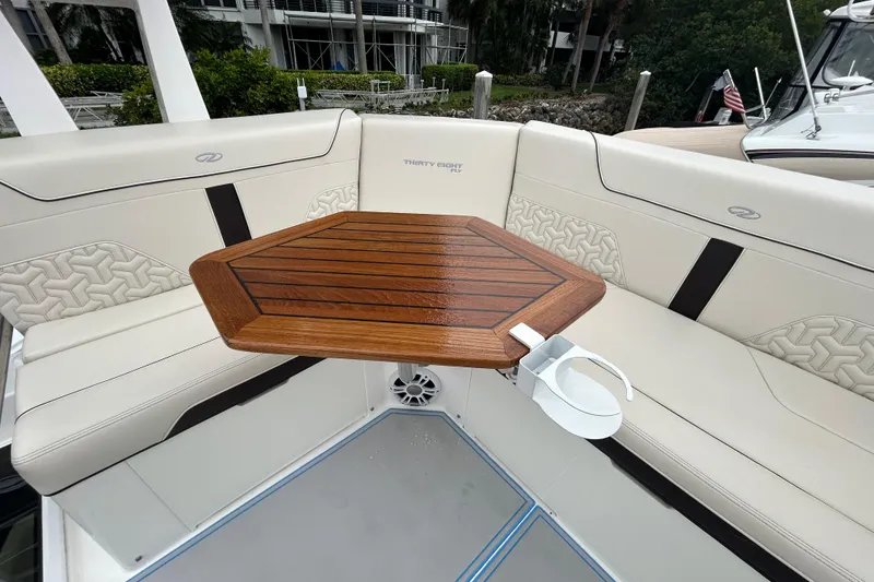 Slide: The Image of Luxurious seating area on 2023 Regal 38 FXO boat with wooden table and cup holder. - 28