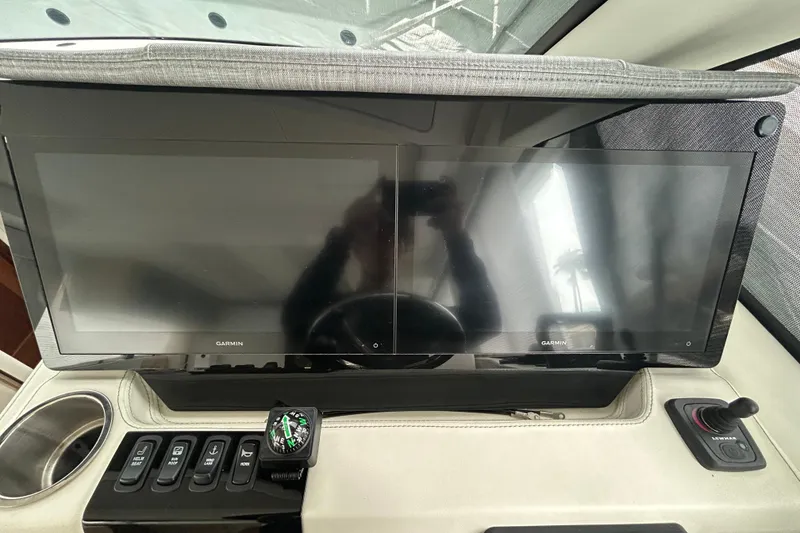 Slide: The Image of Dual Garmin displays on 2023 Regal 38 FXO yacht dashboard with control panel and compass. - 67