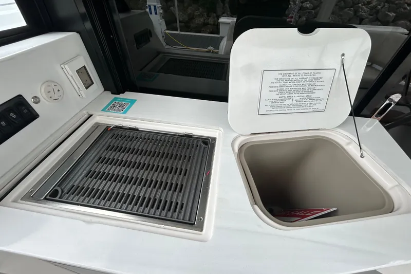 Slide: The Image of Outdoor kitchen area on a 2023 Regal 38 FXO boat with grill and storage compartment. - 49