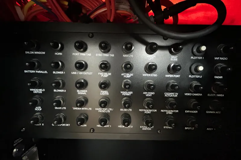 Slide: The Image of Control panel of a 2023 Regal 38 FXO boat with labeled switches and wiring. - 73