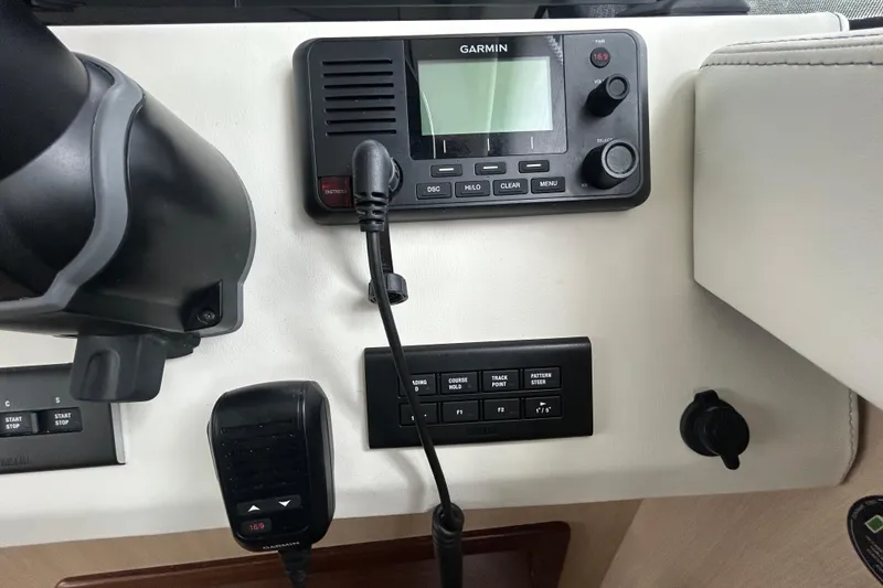 Slide: The Image of Control panel of 2023 Regal 38 FXO boat featuring Garmin navigation system and microphone. - 69