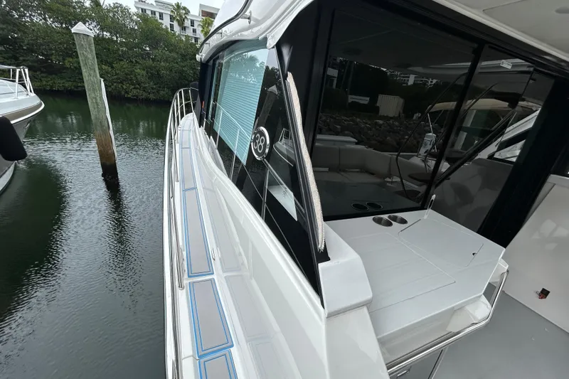 Slide: The Image of 2023 Regal 38 FXO yacht docked, showcasing sleek design and spacious deck area. - 45