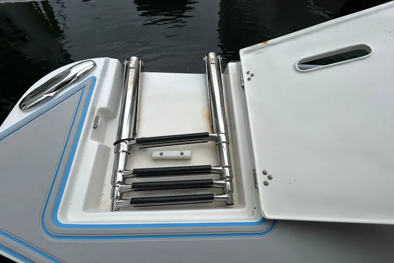 Slide: The Image of 2023 Regal 38 FXO boat ladder with stainless steel steps and open hatch. - 15