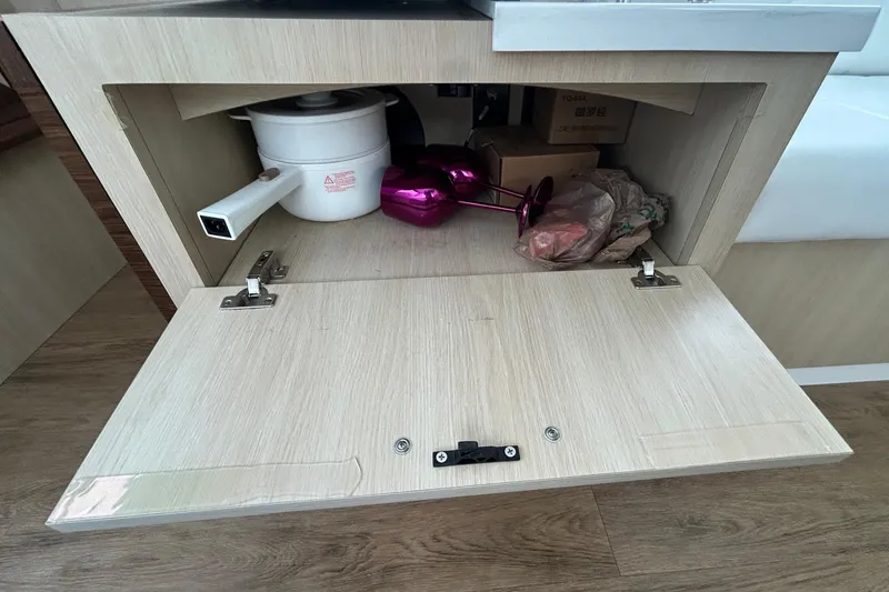 Slide: The Image of Open cabinet on 2023 Regal 38 FXO yacht with kitchen items inside. - 60