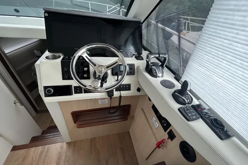 Slide: The Image of Helm of 2023 Regal 38 FXO boat with modern controls and steering wheel. - 64