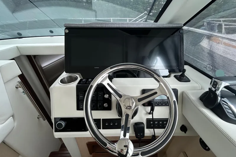 Slide: The Image of 2023 Regal 38 FXO helm with modern steering wheel and dual display screens. - 65