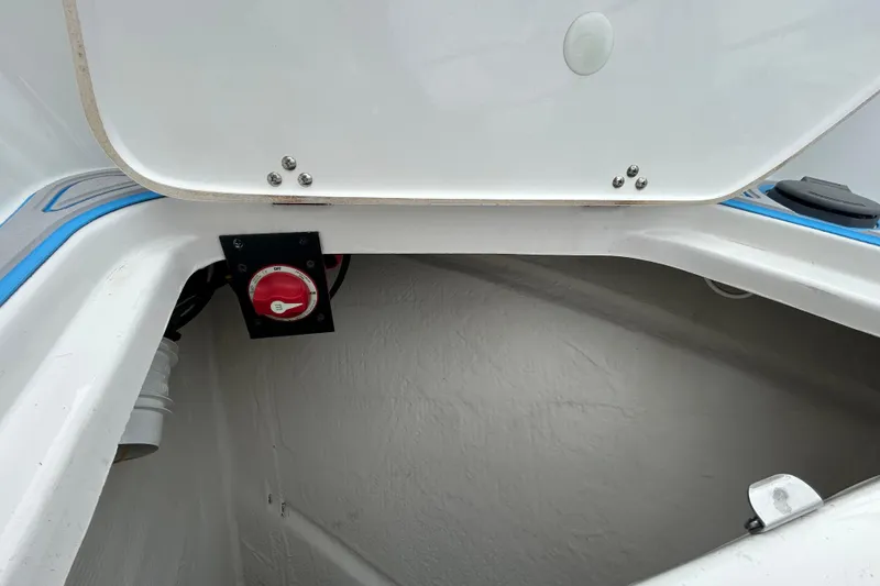 Slide: The Image of 2023 Regal 38 FXO boat compartment with red battery switch and white interior. - 43