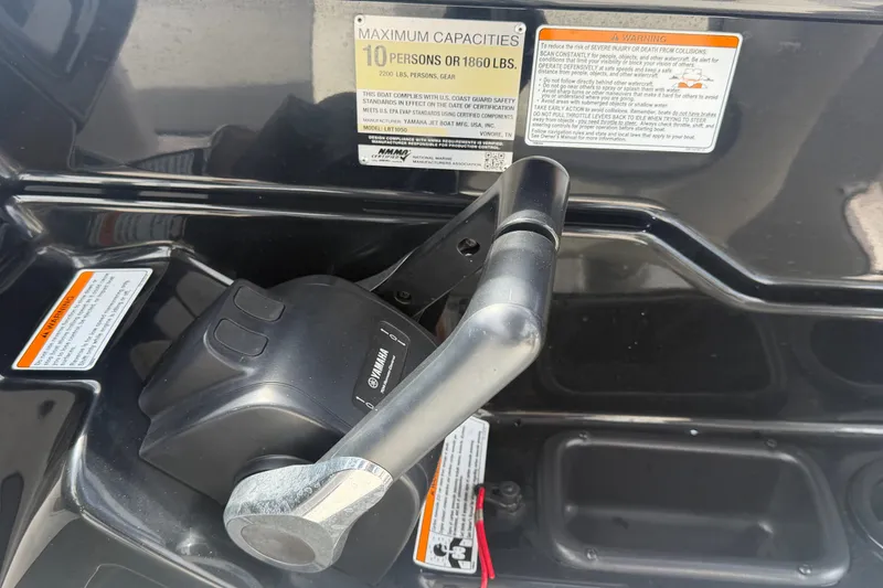 Slide: The Image of Control panel of 2022 Yamaha Boats AR210, showing capacity and safety warnings. - 29