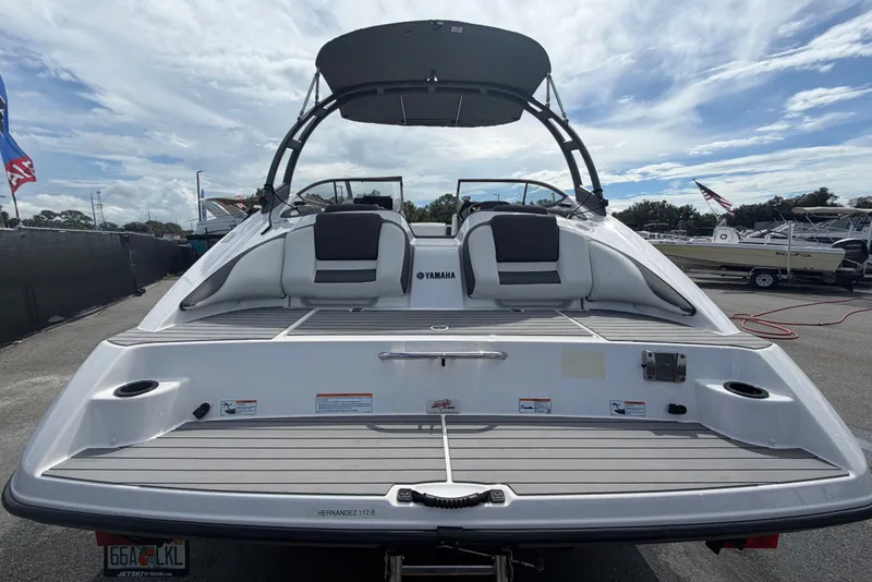 Slide: The Image of The image shows a 2022 Yamaha AR210 boat with a spacious rear deck and a Bimini top. - 3