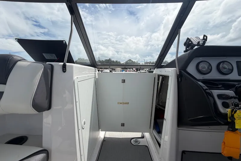 Slide: The Image of 2022 Yamaha AR210 boat interior with open storage compartment and dashboard view. - 37
