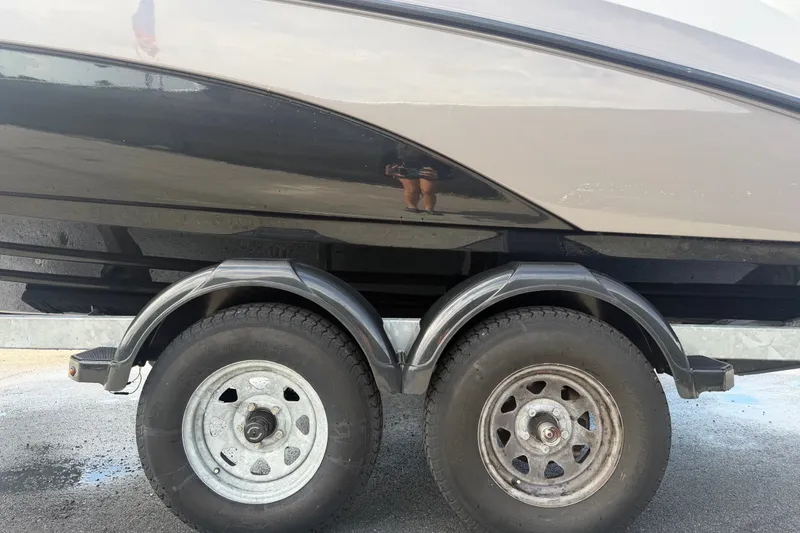 Slide: The Image of 2022 Yamaha Boats AR210 trailer with dual wheels on a paved surface. - 68