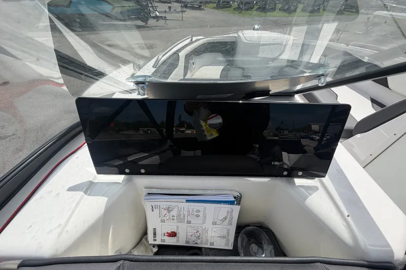 Slide: The Image of 2022 Yamaha Boats AR210 dashboard with windshield and instruction manual visible. - 20