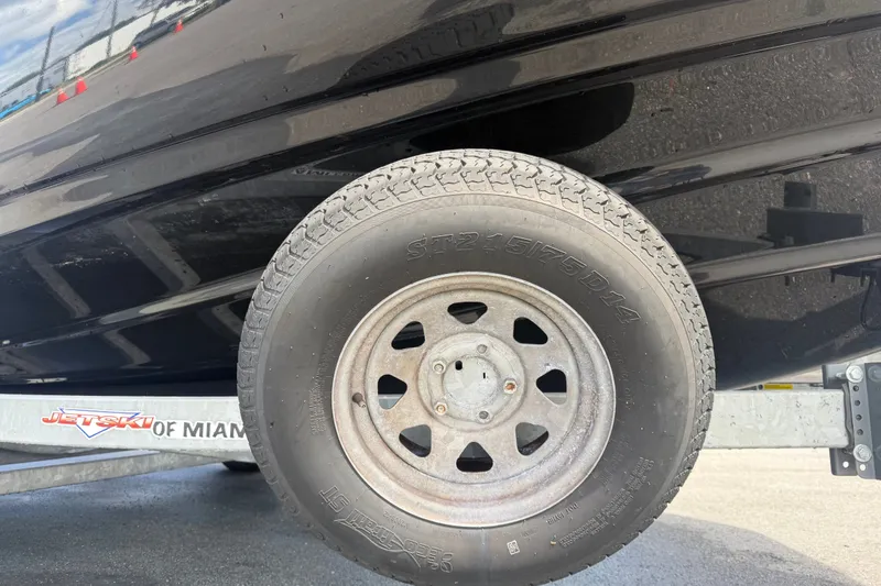 Slide: The Image of Trailer wheel of 2022 Yamaha Boats AR210, parked on pavement. - 66